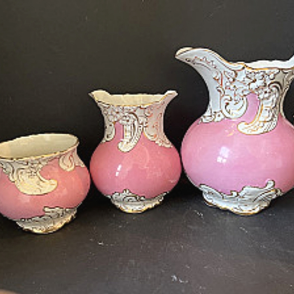 Antique LaBelle porcelain set of 3 lightpink pitchers with white & gold designs.